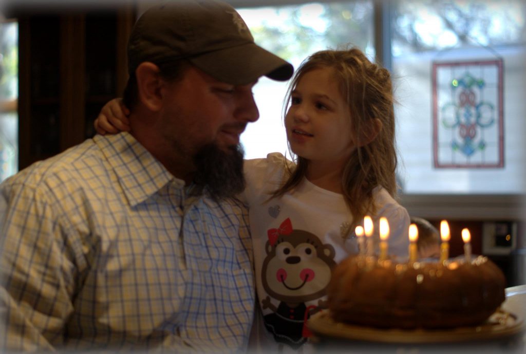 little girl and father celebrating a birthday next to a sourdough apple cake