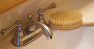 a skin brush next to a white sink