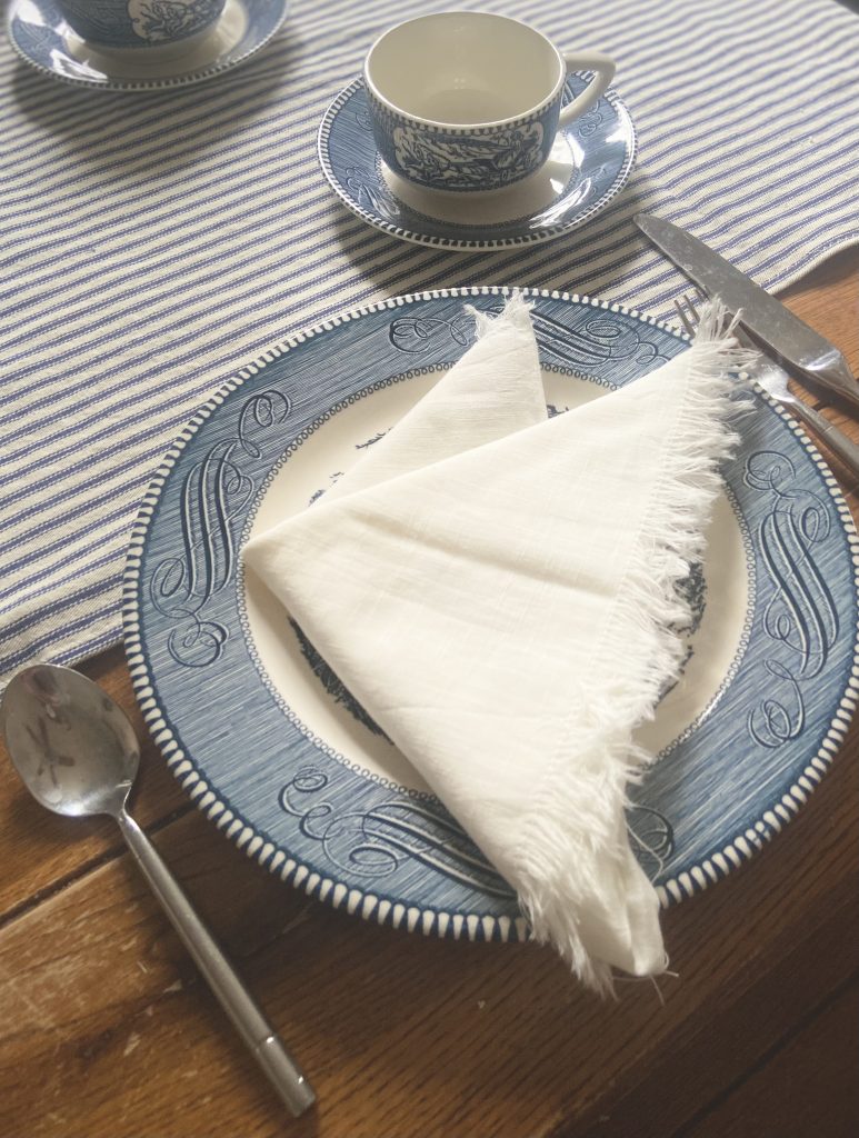 white table linen napkin on a blue and white ironstone plate