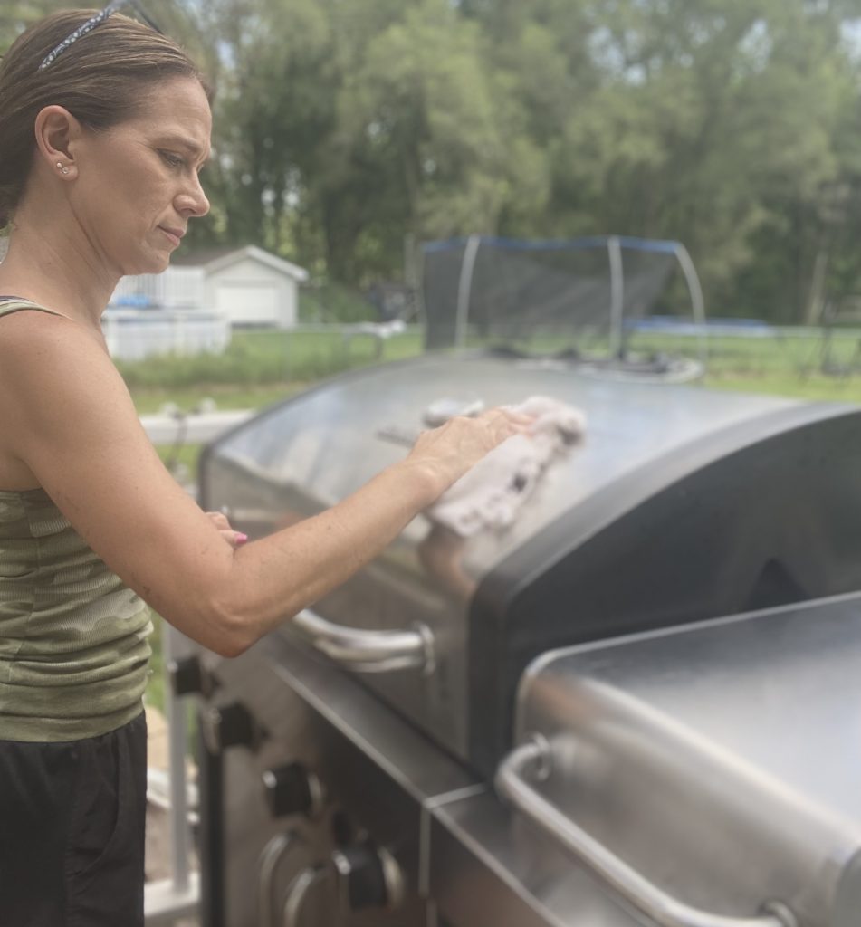woman drying a gas grill
