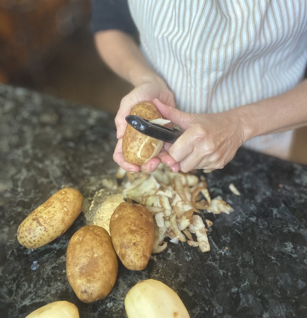 woman peeling potatoes for mashed potatoes