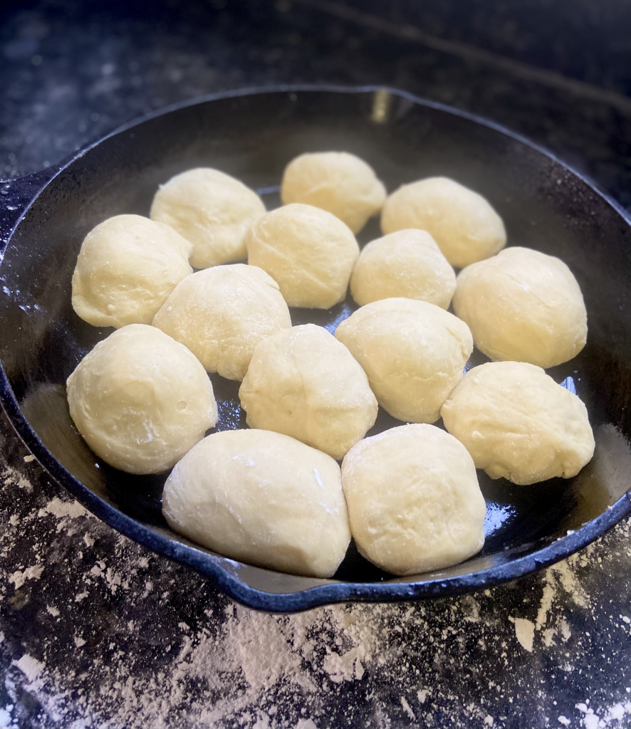 sweet dinner rolls in a cast iron skillet ready to proof