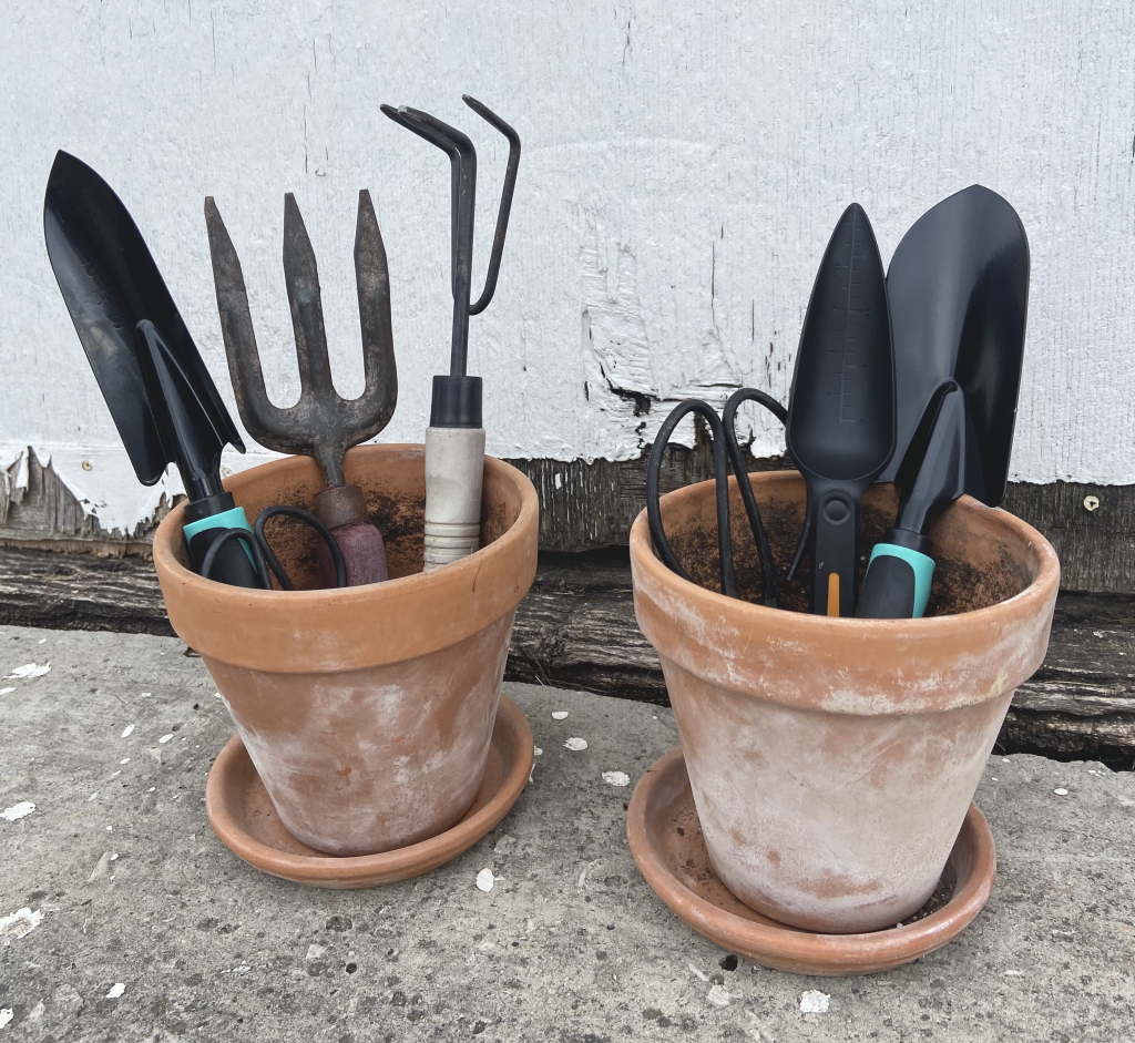 essential garden tools in terra cotta pots