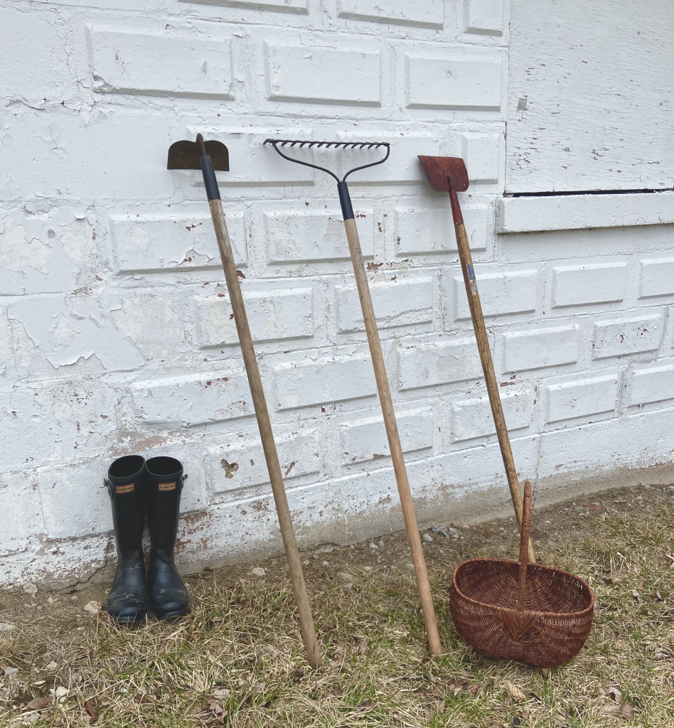 outdoor gardening tools next to a brick tool wall