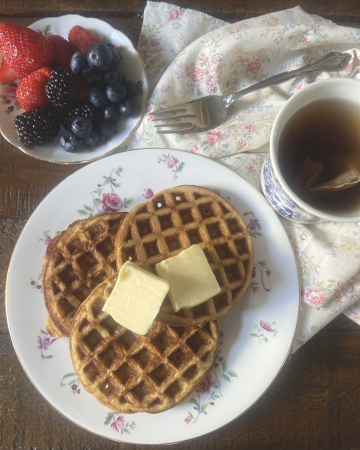 sourdough waffles next to hot tea and berries