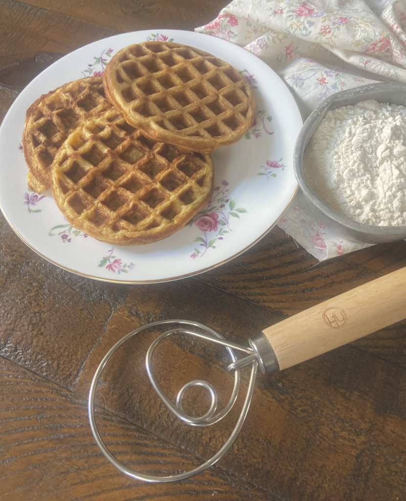waffles on a pink and white plate next to a Danish hook