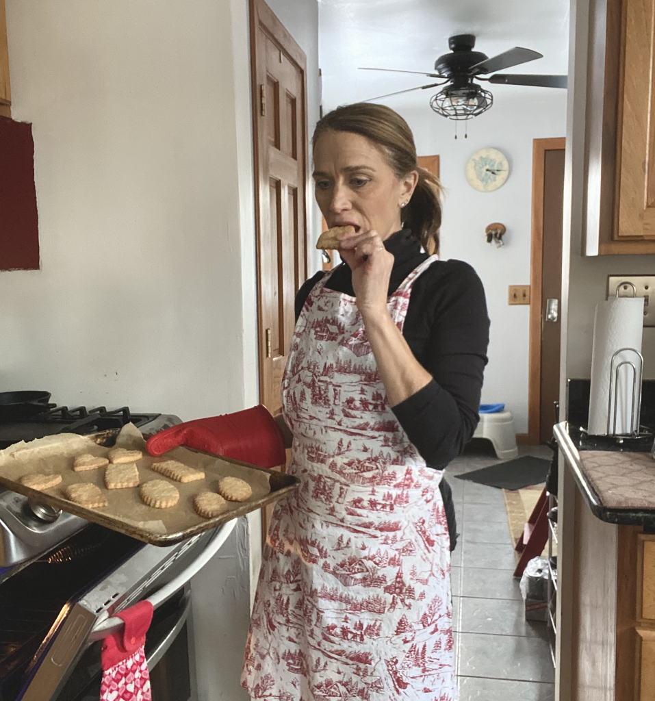 woman eating a freshly baked cookie from the oven