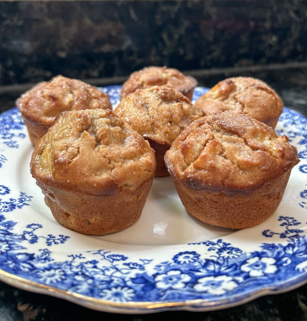 easy sourdough apple cinnamon muffins displayed on a blue and white ironstone plate