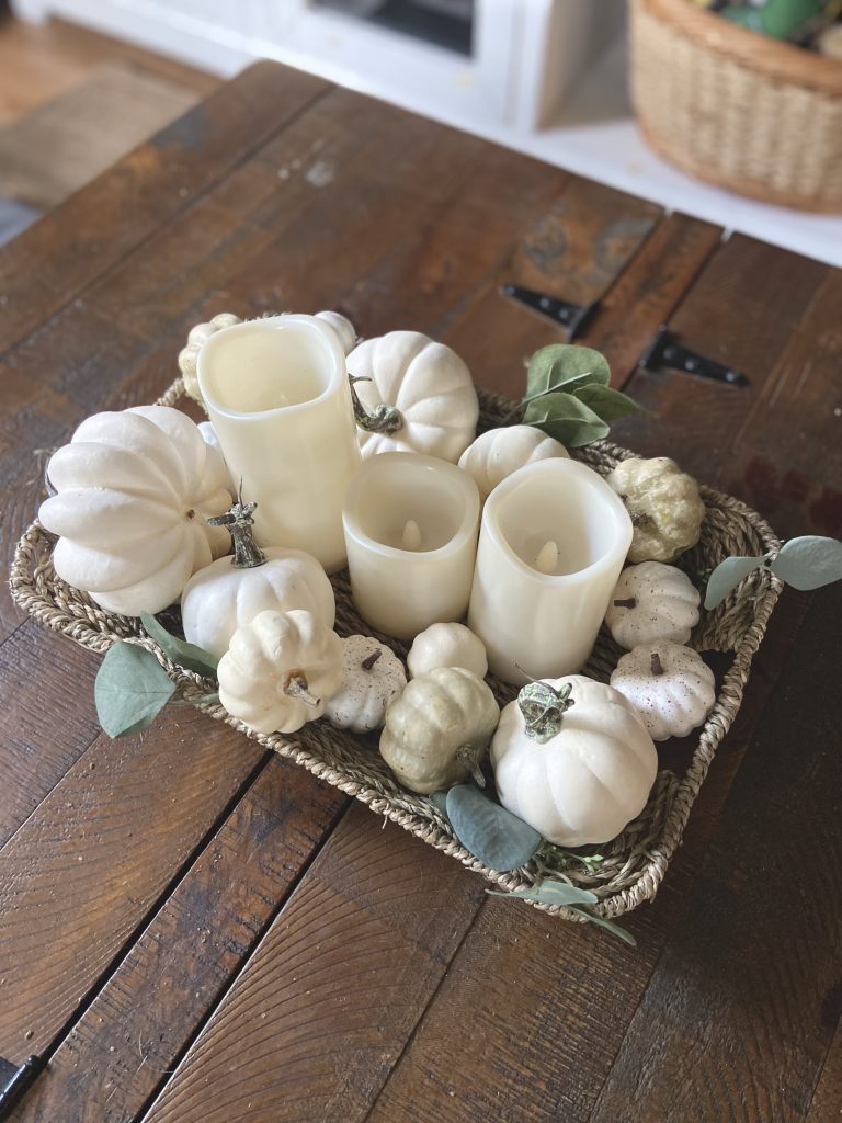 white pumpkins in a wicker basket on a coffee table