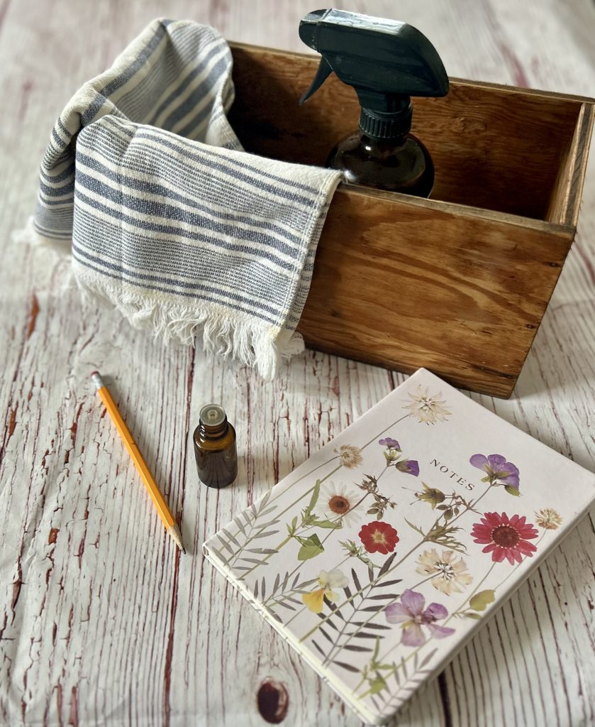 Natural Cleaning Kit next to a flower book and essential oil bottle
