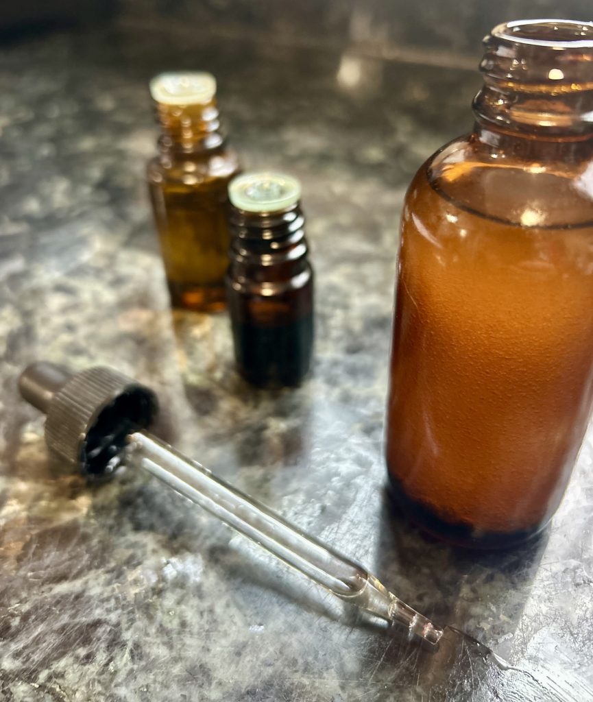 essential oils next to a dropper and brown glass bottle