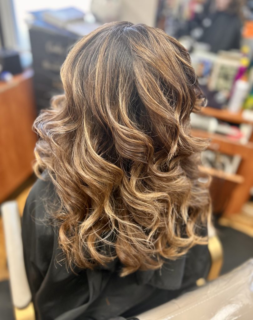 woman with thick curly hair posing after using argan oil